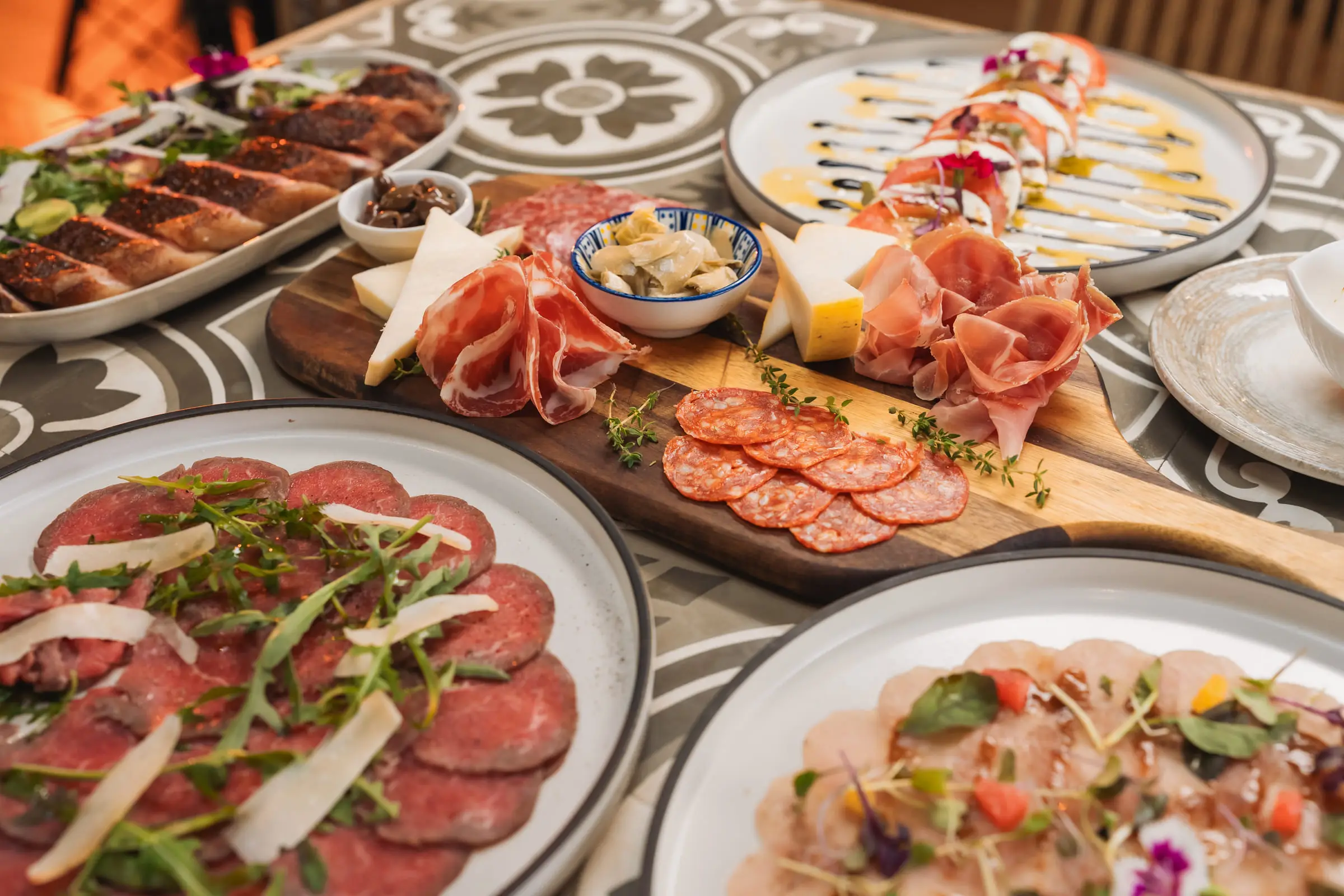 Antipasti to share — carpaccio, cured meats and a board of Italian cheeses